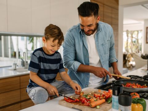 father and son cooking on gas stove image