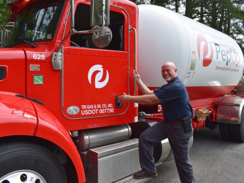 image of home comfort solutions expert by a propane delivery truck
