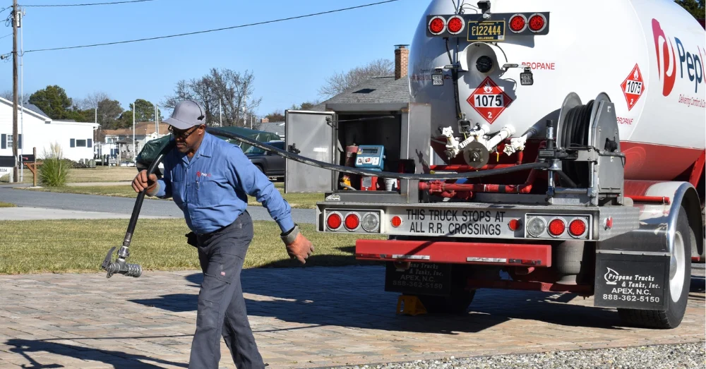How to order emergency propane delivery in winter and stay warm and safe, blog post image of driver delivering home propane.