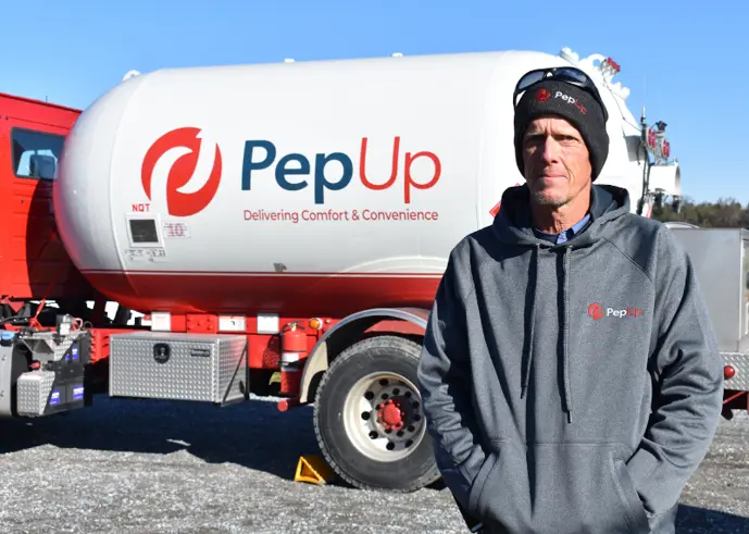 Image of PepUp delivery driver Bryan Pine, with a propane truck set to deliver propane fireplace insert fuel.