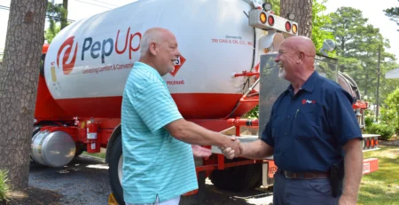 A PepUp customer shakes hands with delivery driver Jeff North and shares what they love about their Rinnai tankless water heater.