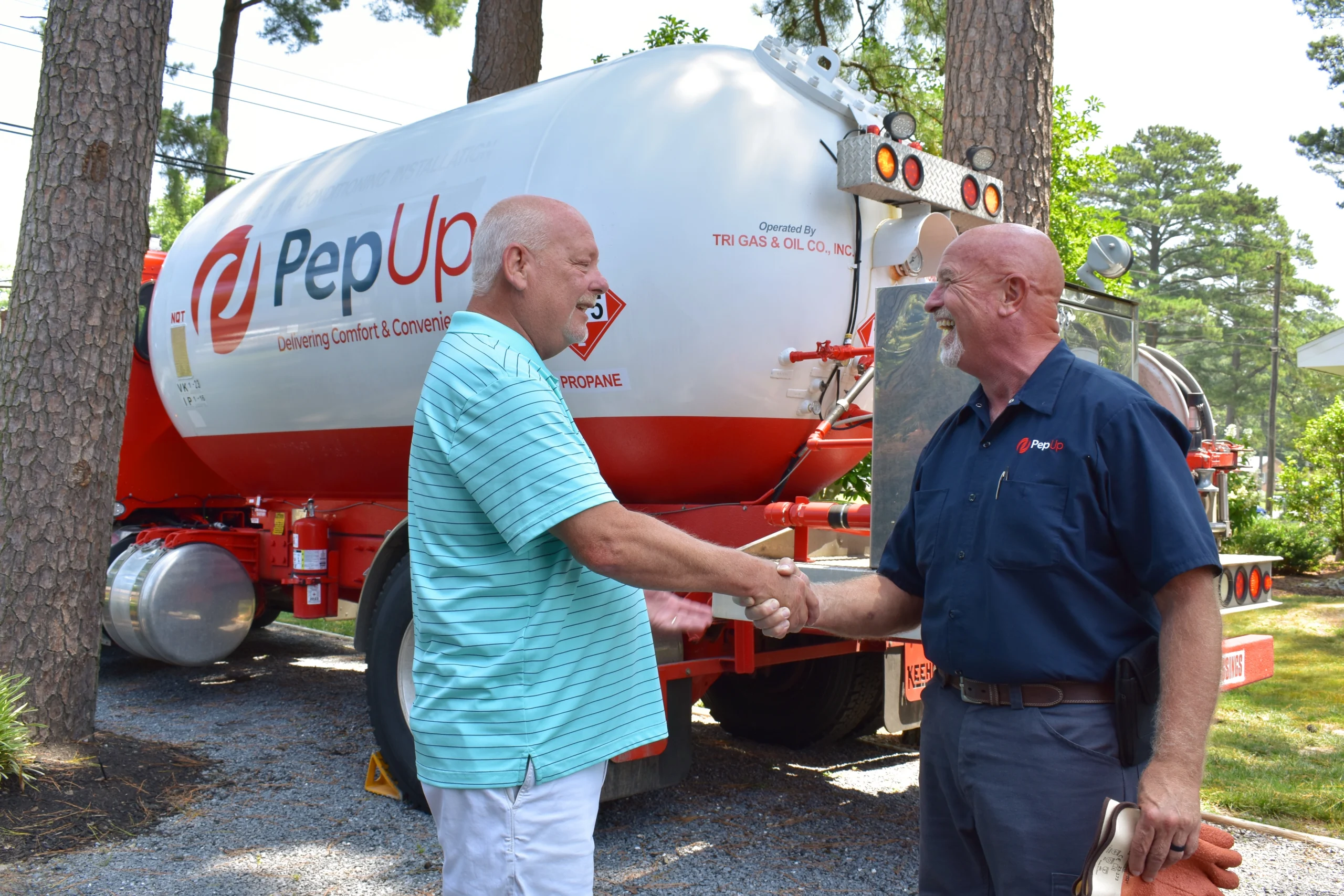 A PepUp customer shakes hands with delivery driver Jeff North and shares what they love about their Rinnai tankless water heater.
