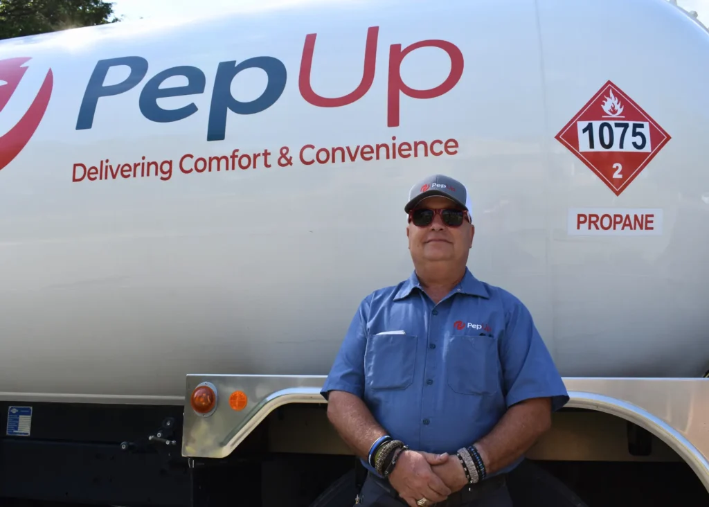 Propane delivery driver Patrick Lanahan poses beside a PepUp propane delivery truck.