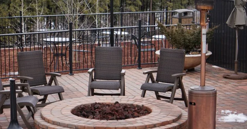 Image of a brick patio fire pit area using propane options to heat patio.