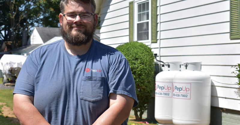 PepUp driver stands in front of newly set propane tanks.