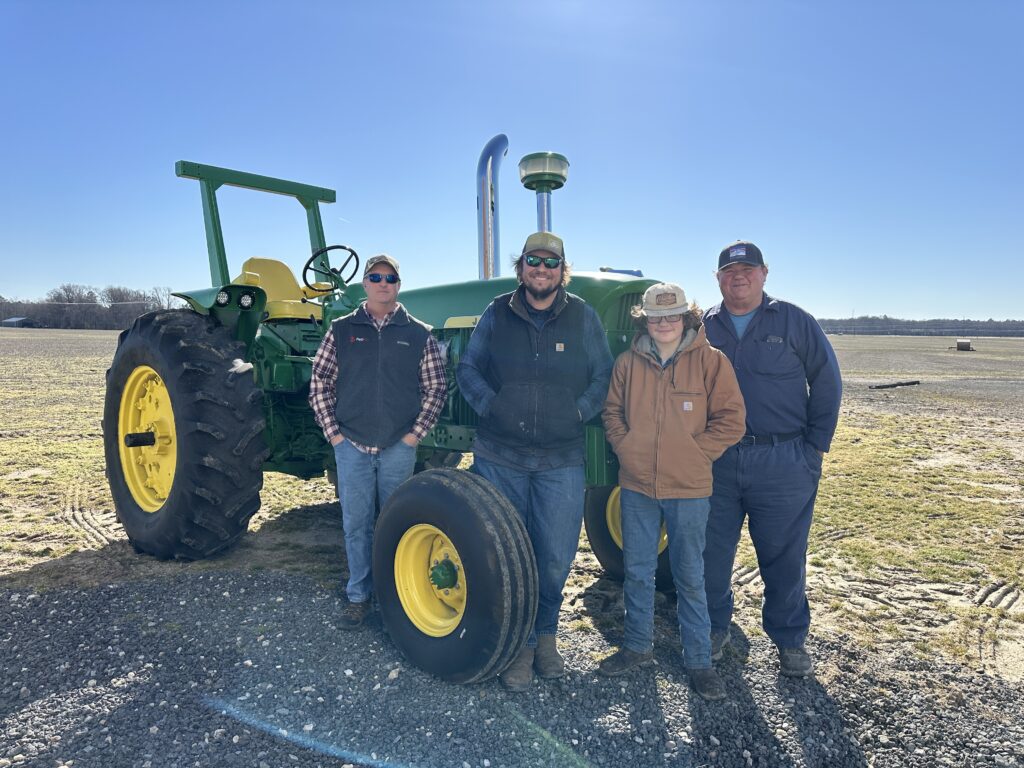 A PepUp agriculture fuel specialist visits a three-generation farming family in Maryland, posing in front of one of their fleet of tractors.