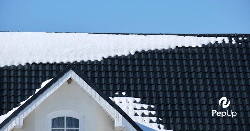 Image of a home's roof with snow, showing areas of poor insulation where heat from inside the home has melted the snow.
