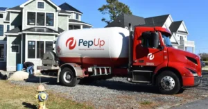 A PepUp propane delivery truck in front of a home on Delmarva, filling a tank after the customer converted to propane from heating oil.